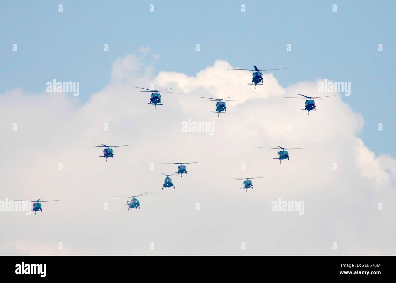 Eleven helicopters in flight approaching as a group Stock Photo