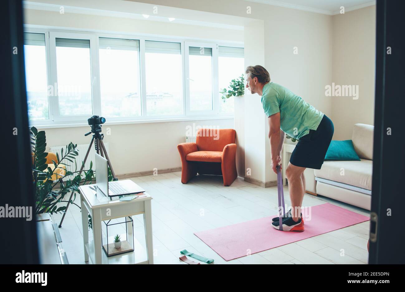Caucasian man is doing fitness exercises on camera at home wearing sportswear Stock Photo