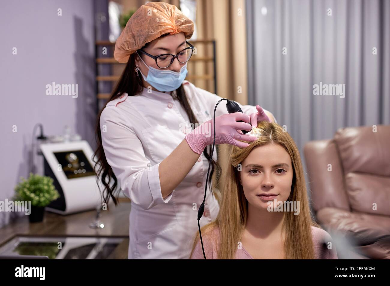 caucasian woman with thinning hair at examination of the scalp and hair