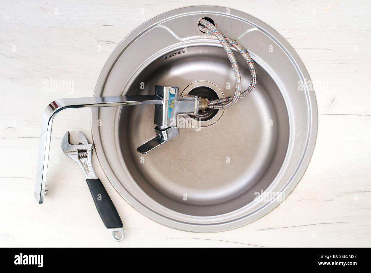 New faucet and adjustable wrench for installing into the kitchen sink Stock Photo Alamy