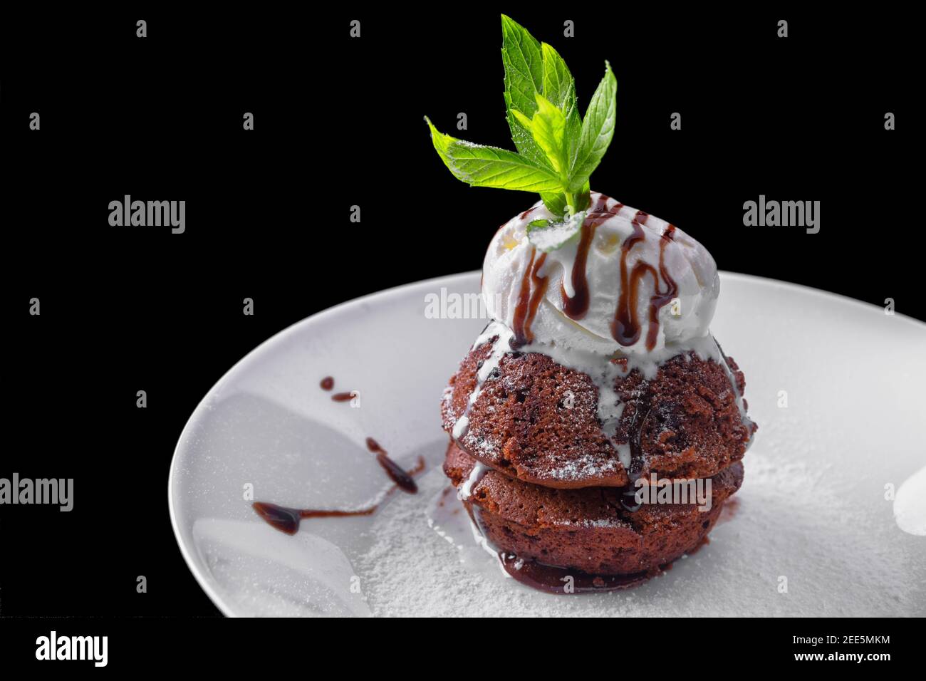 Chocolate fondant with ice cream, on a white plate, with mint and berries Stock Photo