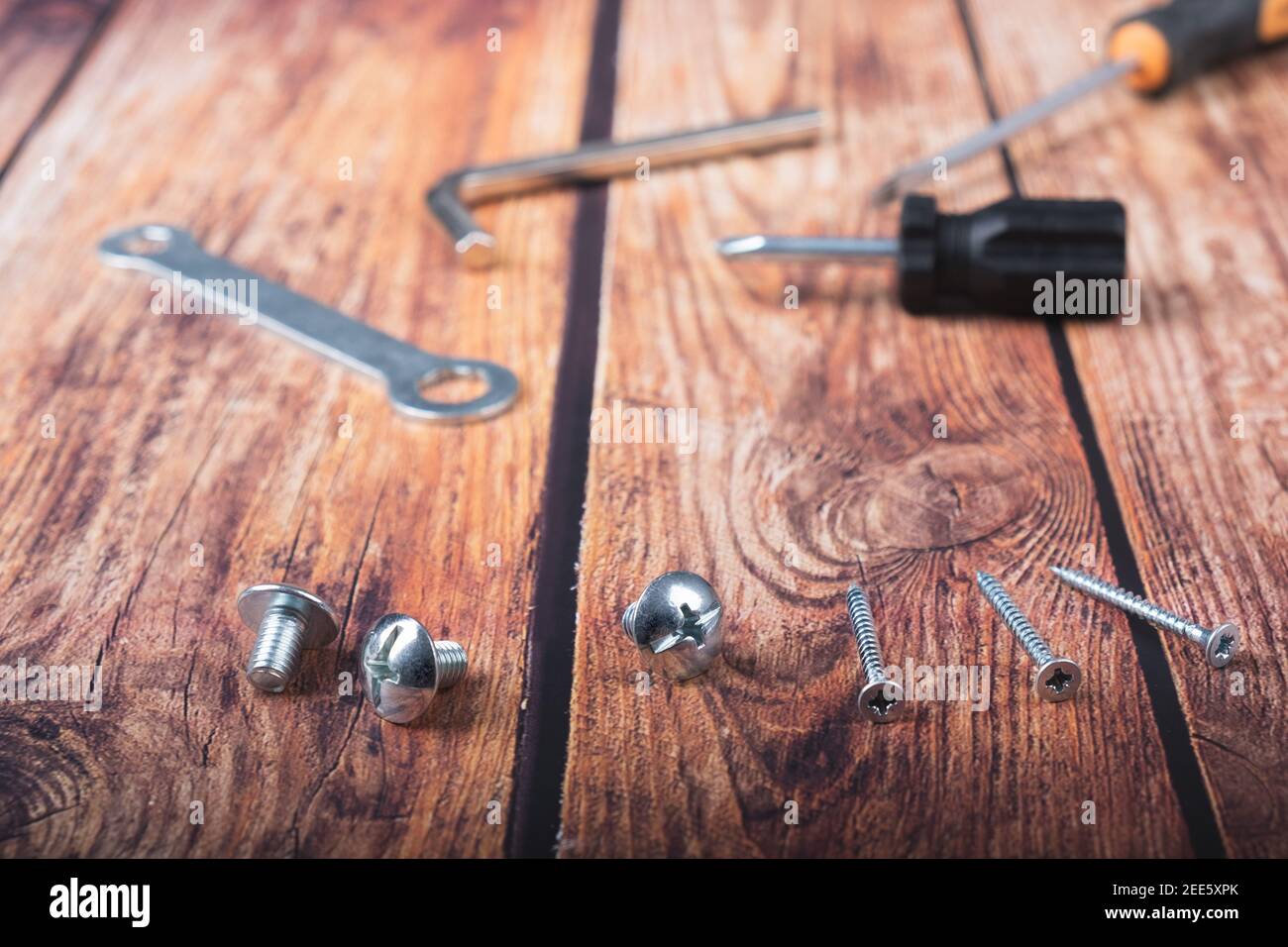 Screws of various sizes on a dark wood background Stock Photo