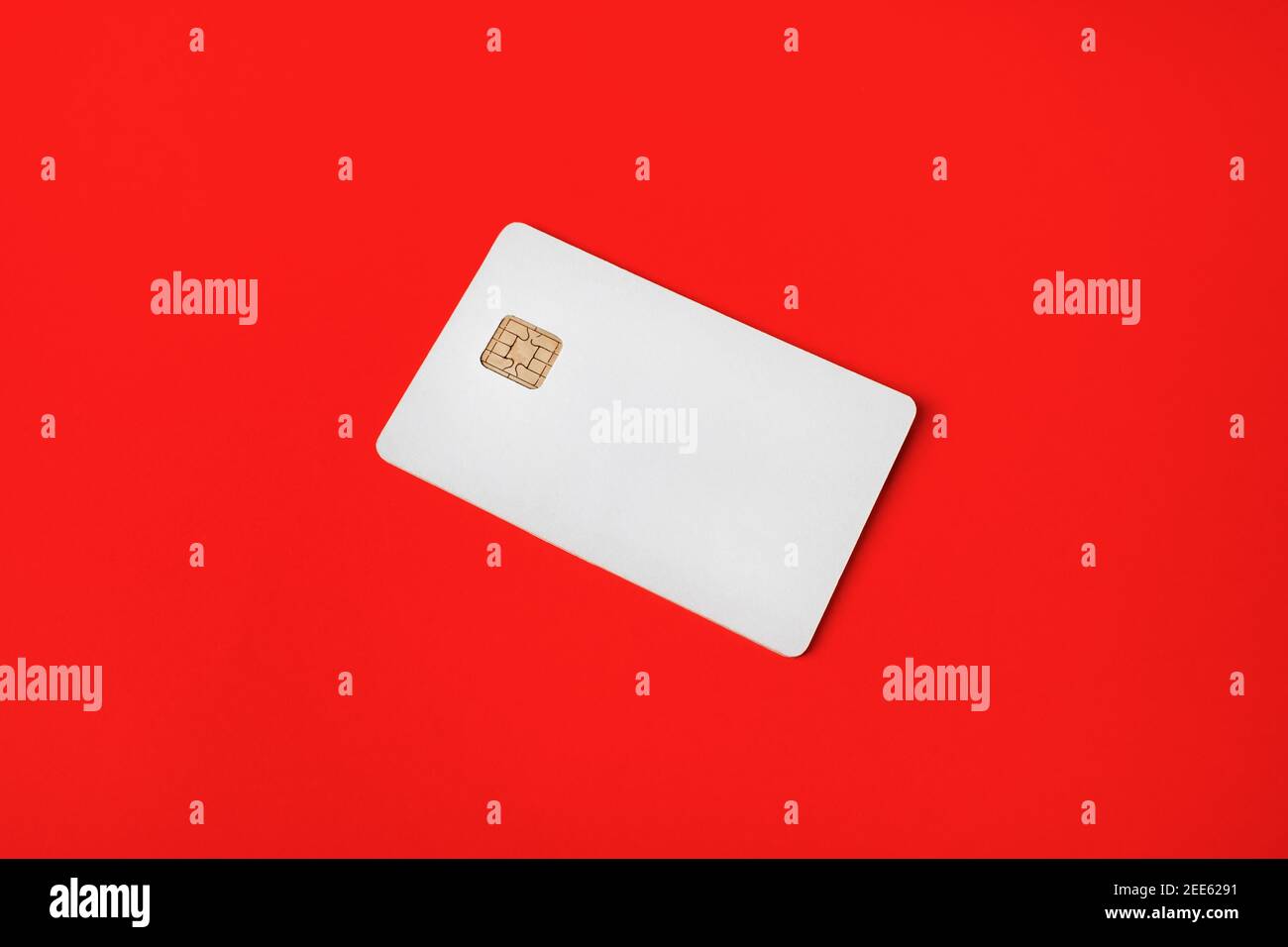Photo of blank credit card on red paper background. White bank card