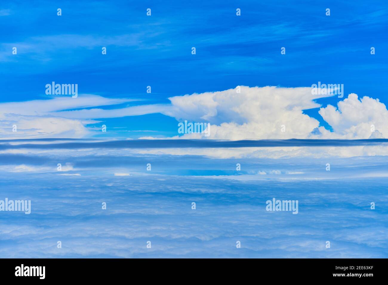 Landscape of fluffy white clouds on a dark blue sky. View from the ...