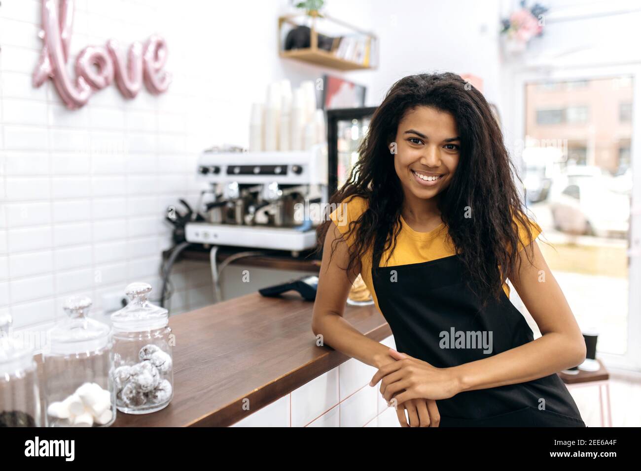 Photo of a friendly waitress wearing uniform, african american female