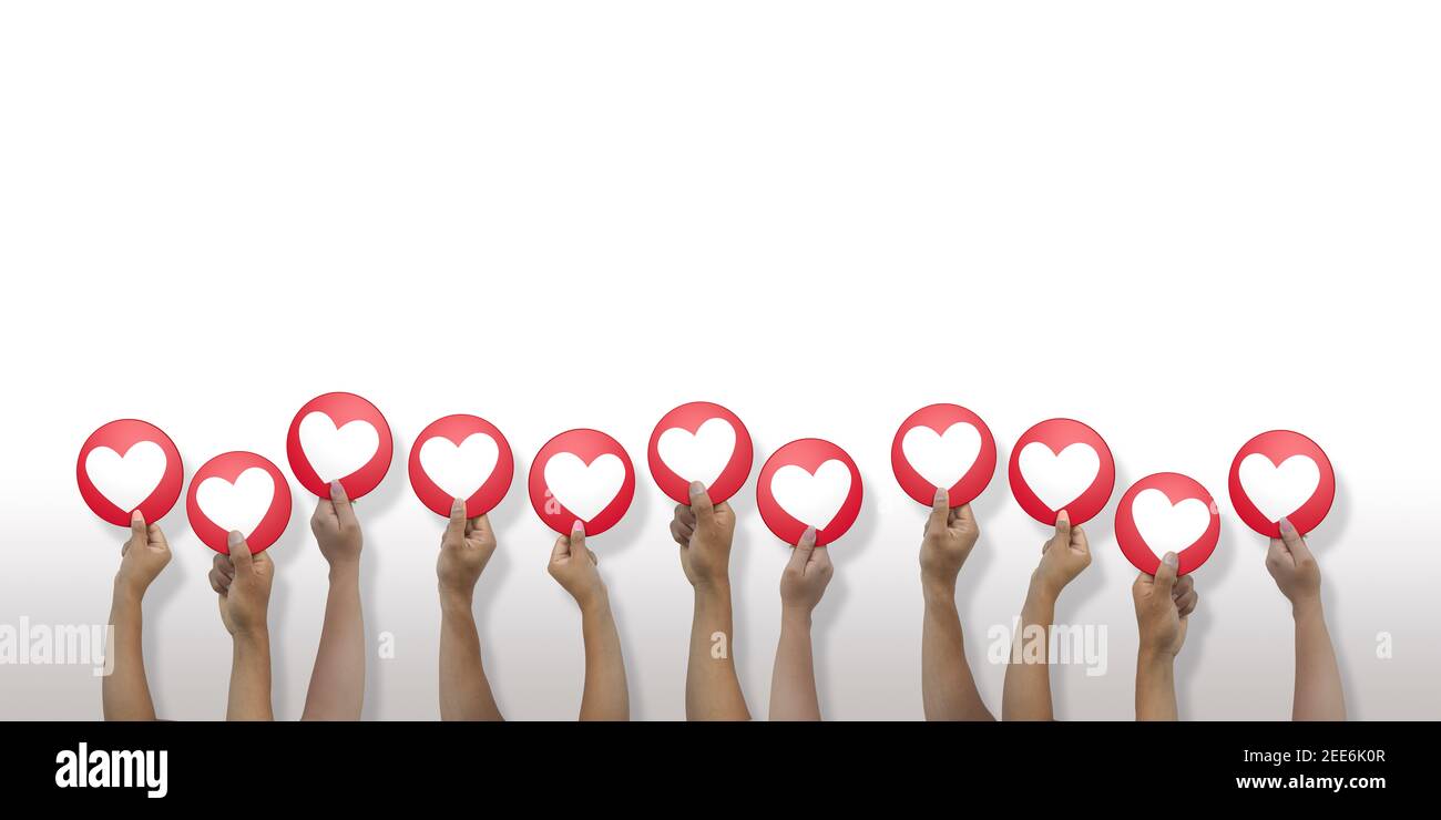 Close up on 11 arms of latin men and women coming out from below holding in hand a round red I LOVE icon on white background Stock Photo