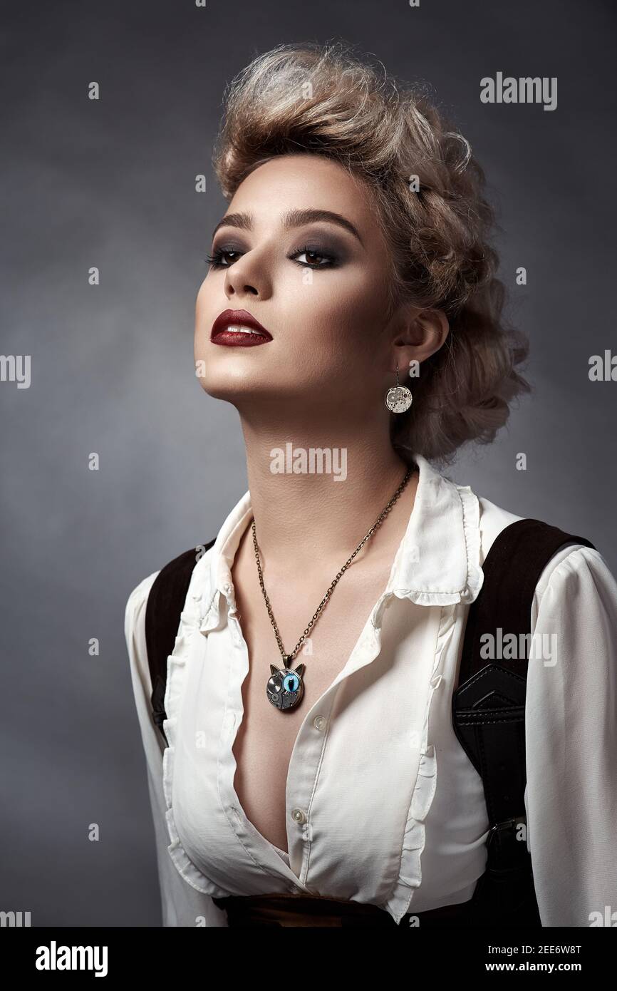 Beautiful blonde girl in steampunk style costume and earrings and necklace Stock Photo