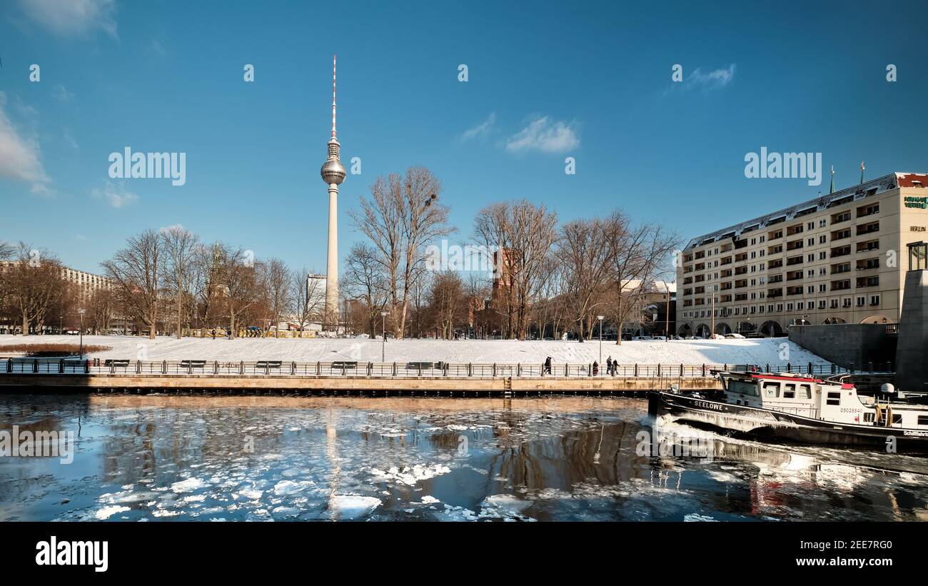 Berlin Riverside Berlin riverside under snow. Boat crashes ice on Spree river. Panoramic ...