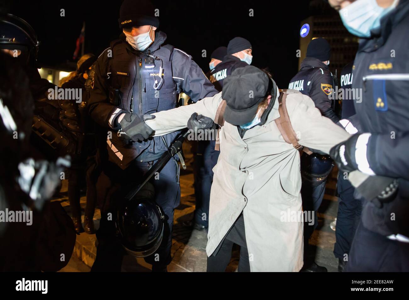 Policemen arrest a woman during an anti-government protest in Ljubljana. The protests against Slovenian Prime Minister Janez Jansa continued on the day that the National Assembly debated a motion of no confidence in the government. The no-confidence vote was initiated by the opposition that accuses the government of authoritarianism. Stock Photo