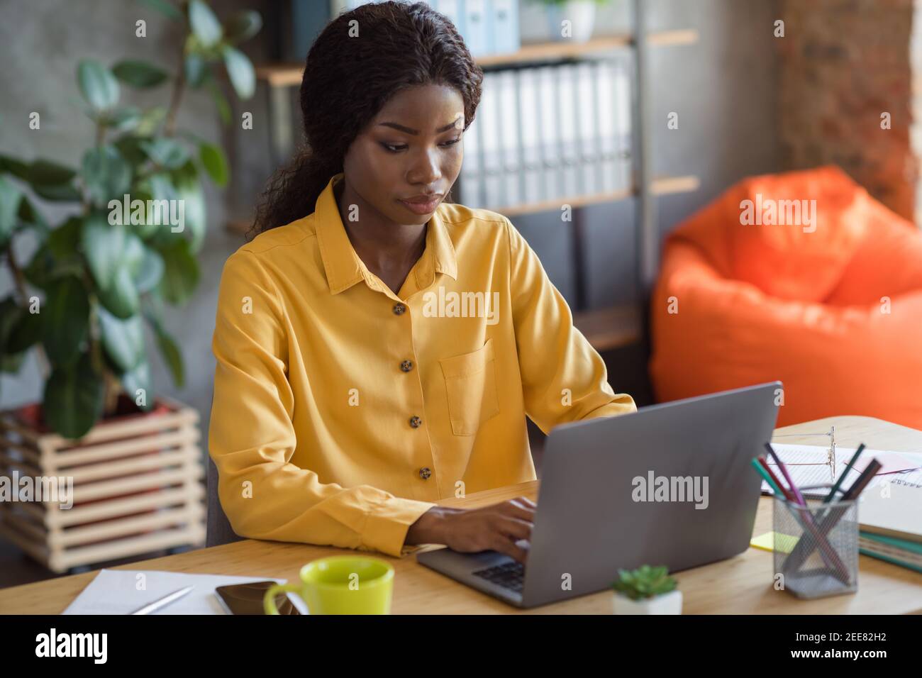 Photo portrait of african american woman working on laptop typing in ...