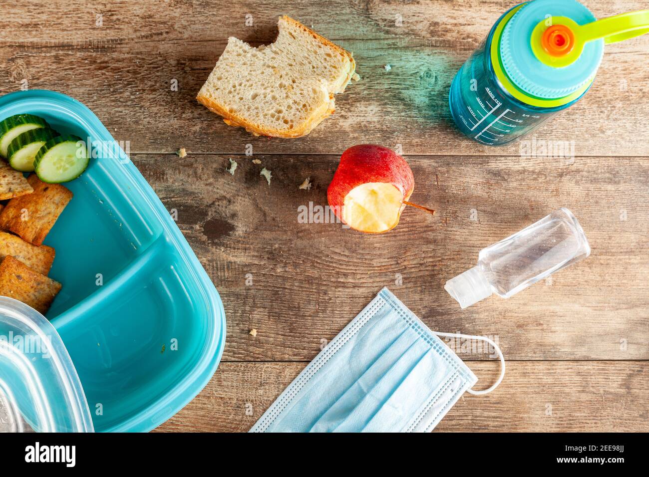 Flat lay image with eating lunch at school concept during the phased reopening after COVID-19 pandemic closures. Snack in containers as well as water Stock Photo