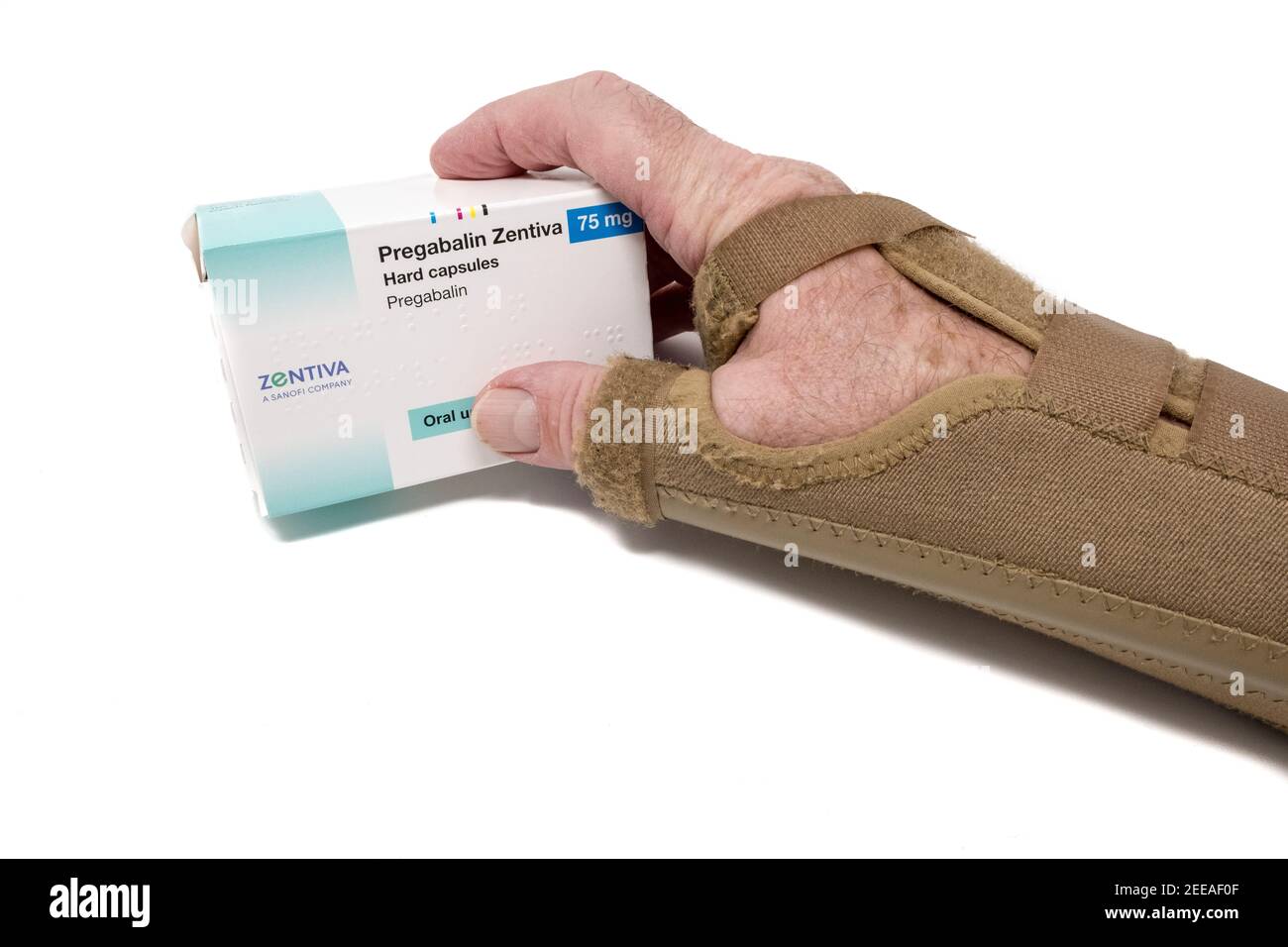 Scaphoid fracture support on mans arm holding box of tablets of Pregabalin for nerve pain Stock Photo