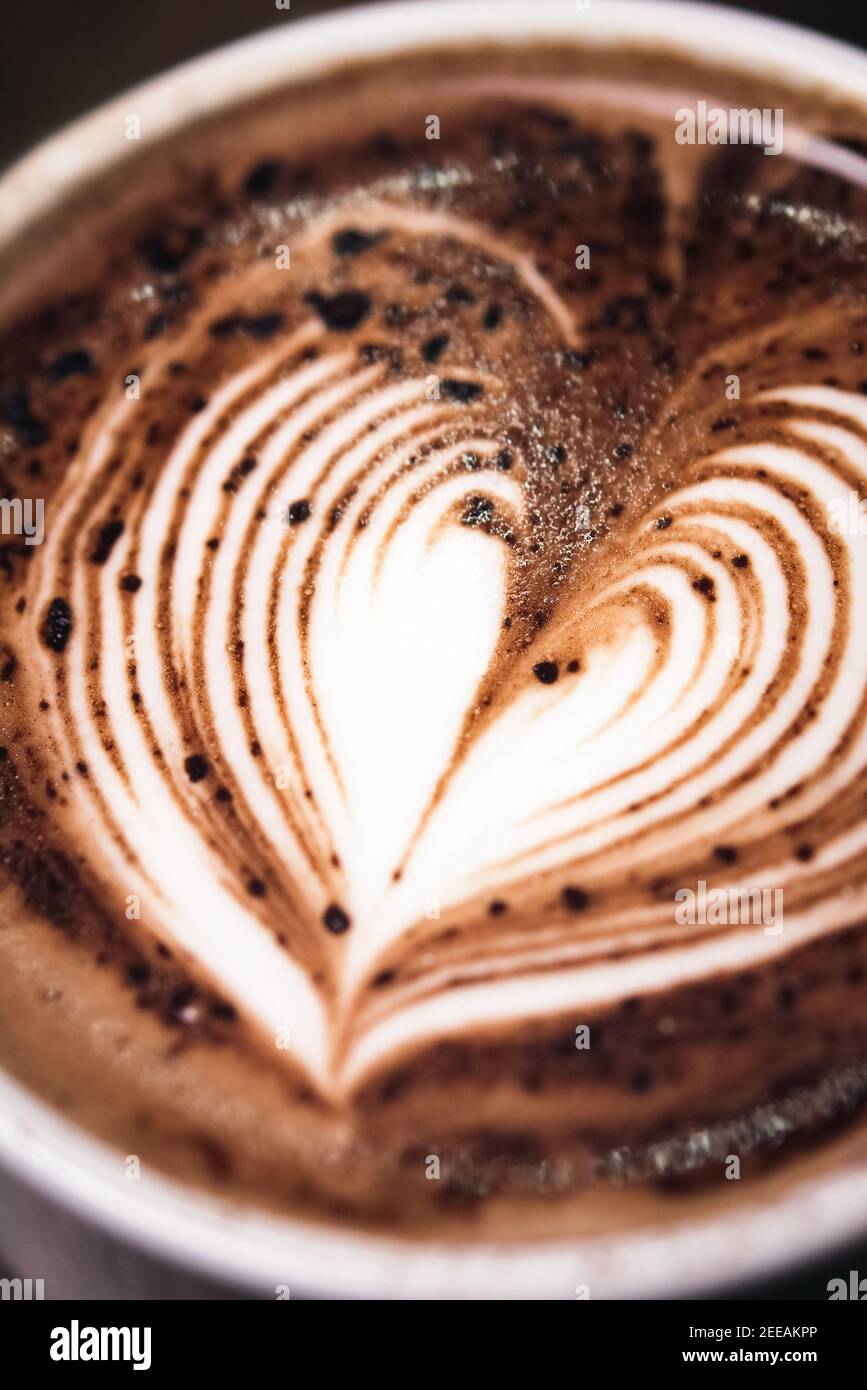 Close up of heart shape latte art on top of hot dark chocolate drink in the cup Stock Photo