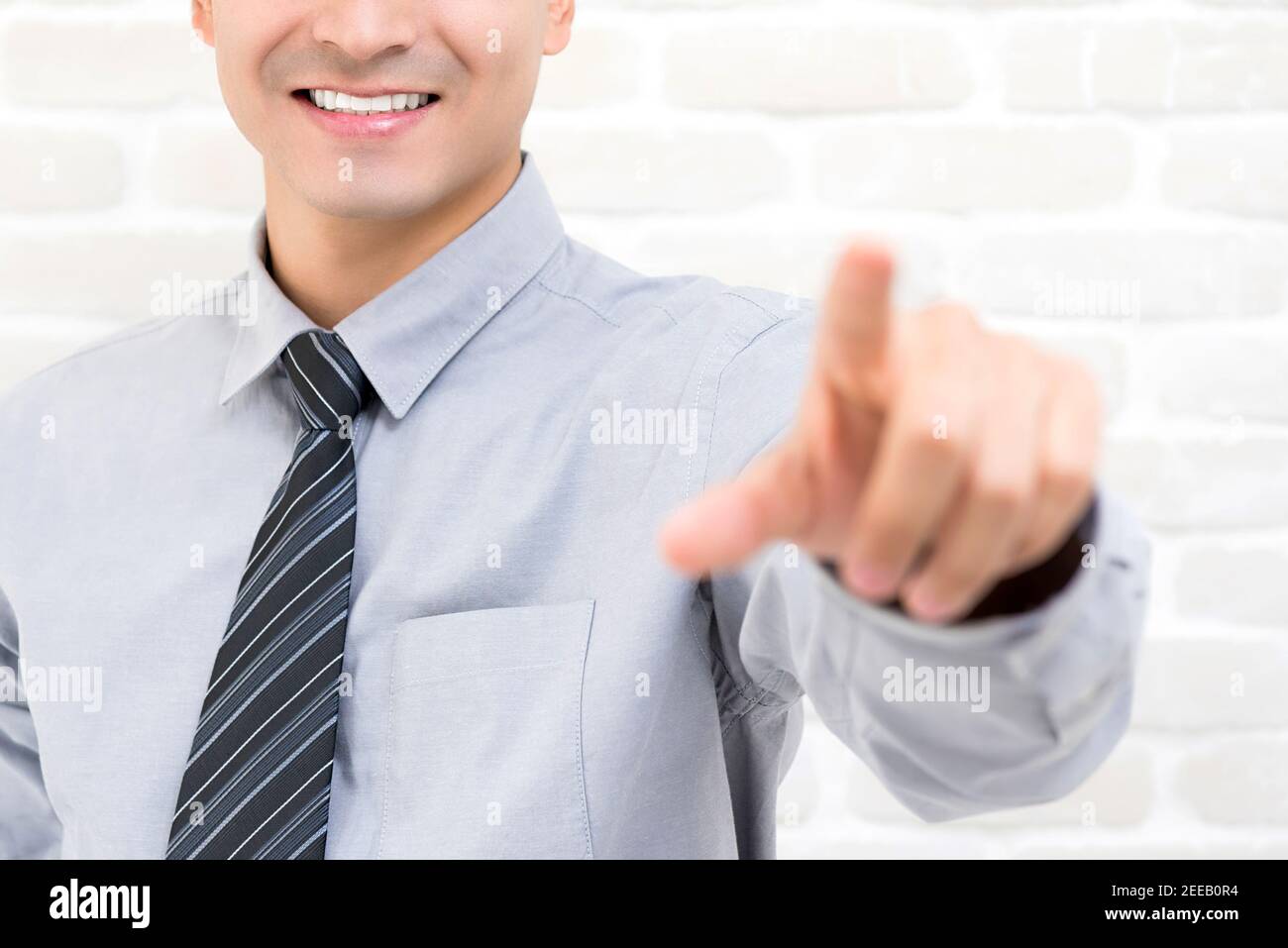 Smiling businessman hand touching on empty imaginary virtual screen Stock Photo