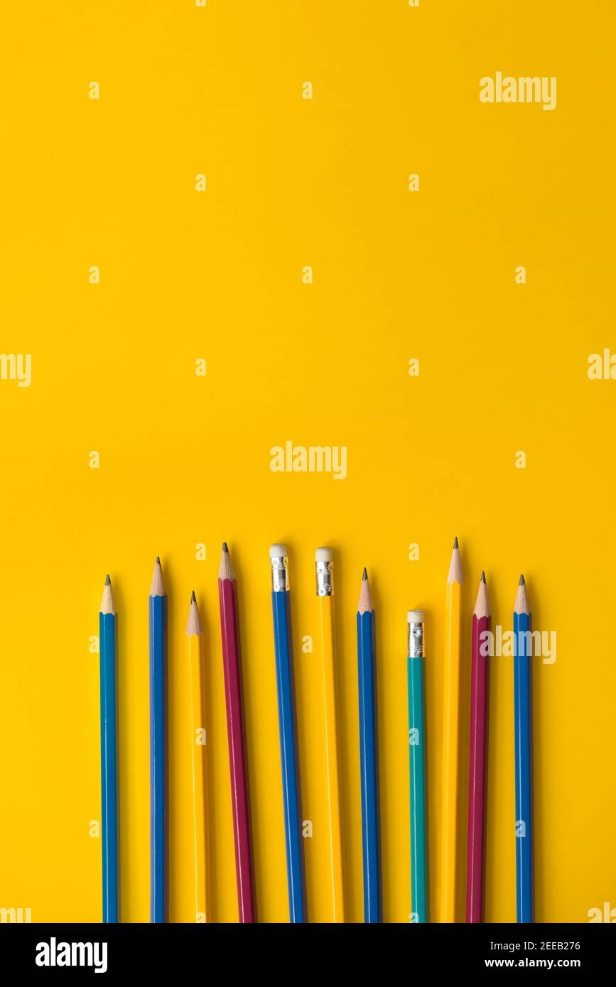 Set of colorful pencils on yellow paper with copy space, educational bakground concept Stock Photo