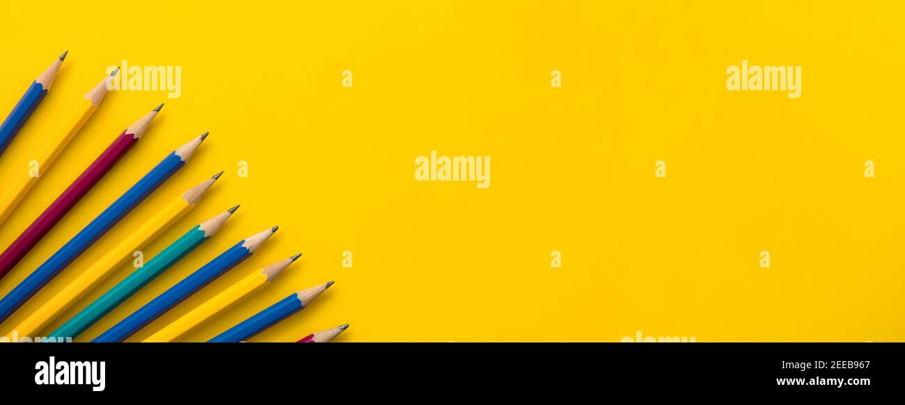 Set of new colorful pencils at border of banner yellow paper, educational bakground concept Stock Photo