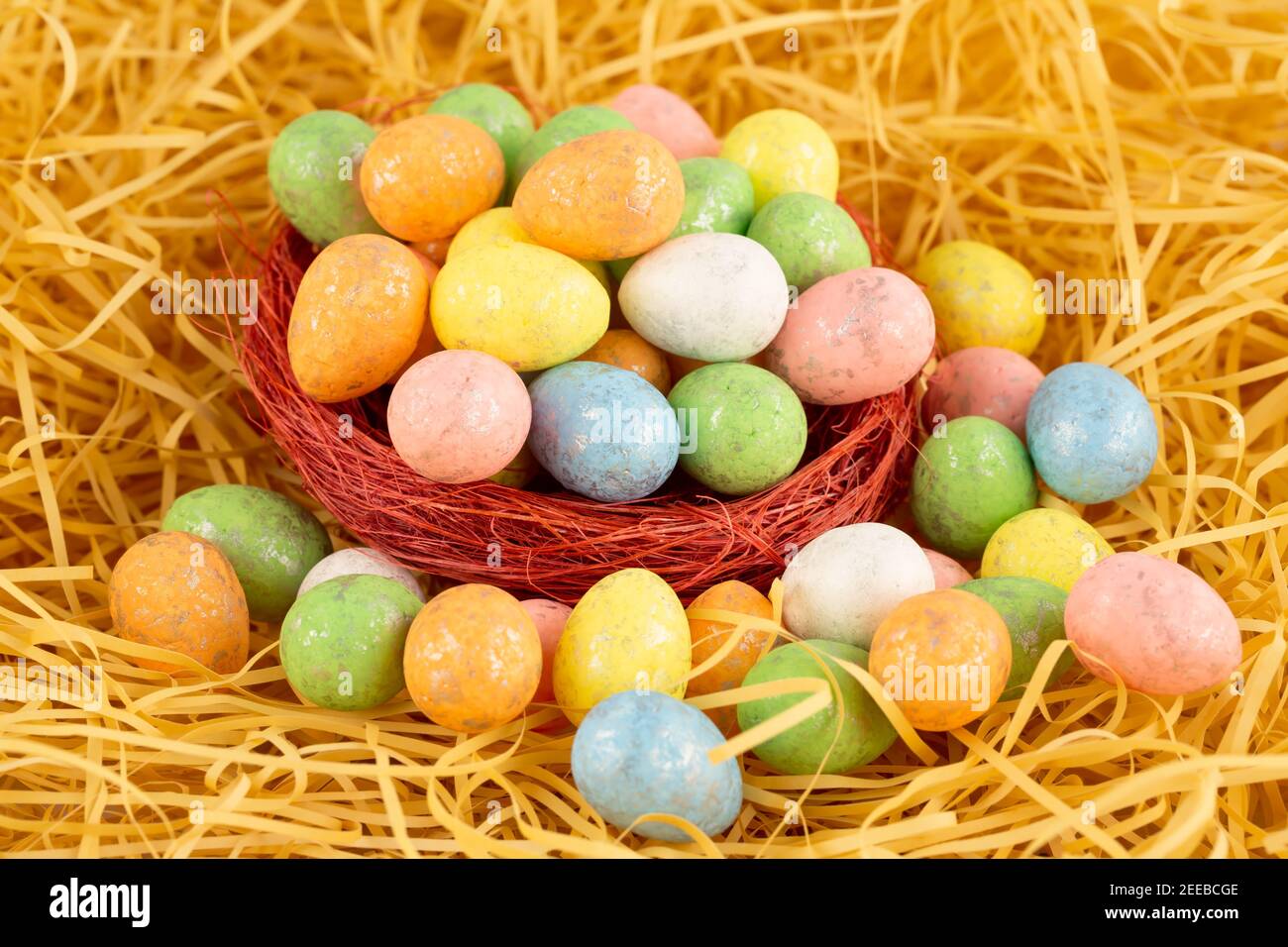 Easter colorful eggs in nest on yellow straw background Stock Photo - Alamy
