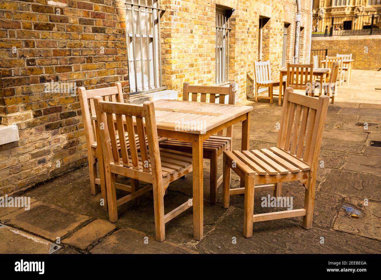 Wooden tables and chairs of outdoors cafe in London. Stock Photo