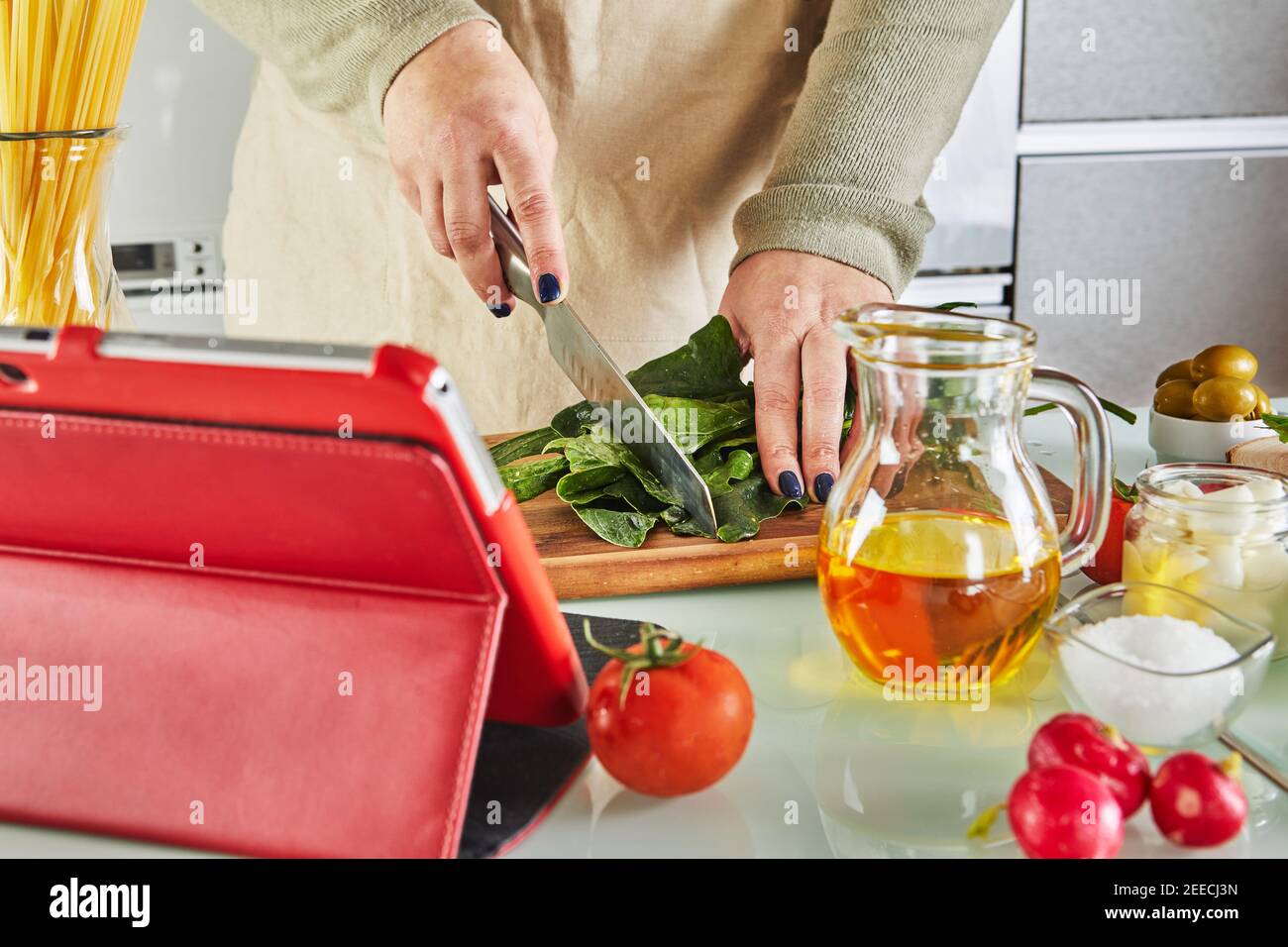 Woman cooking according the tutorial of online virtual master class ...