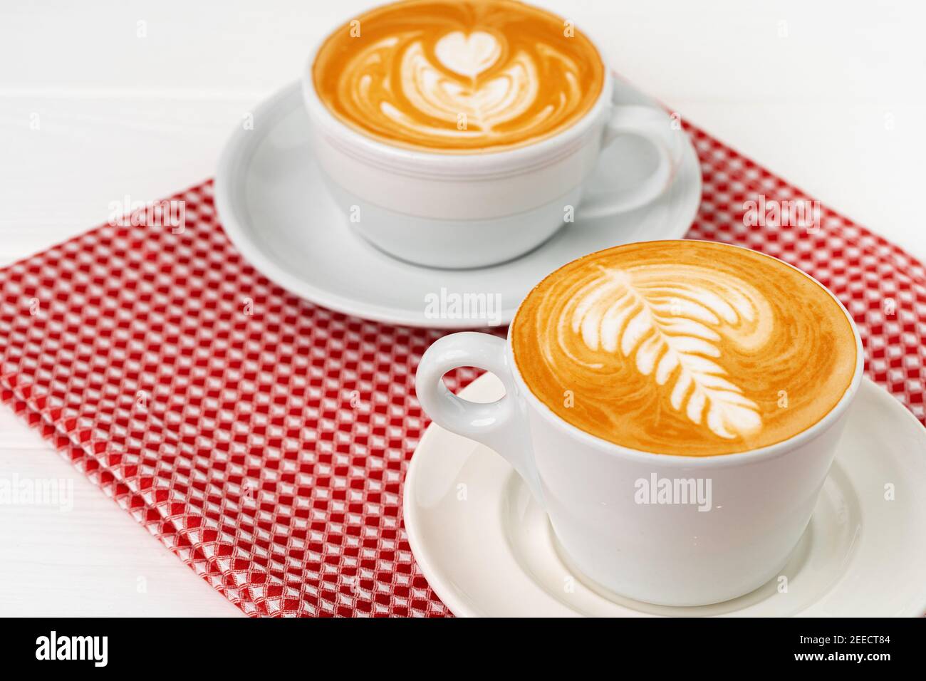 Cup of hot coffee with art on froth Stock Photo - Alamy