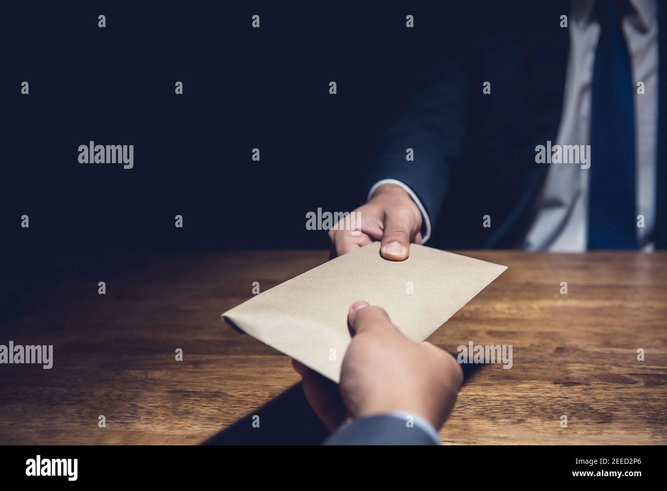 Businessman giving bribe money in brown envelope to partner in a