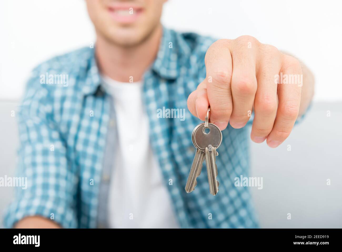 A man in casual wear giving house keys to the new owner (tenant) Stock Photo