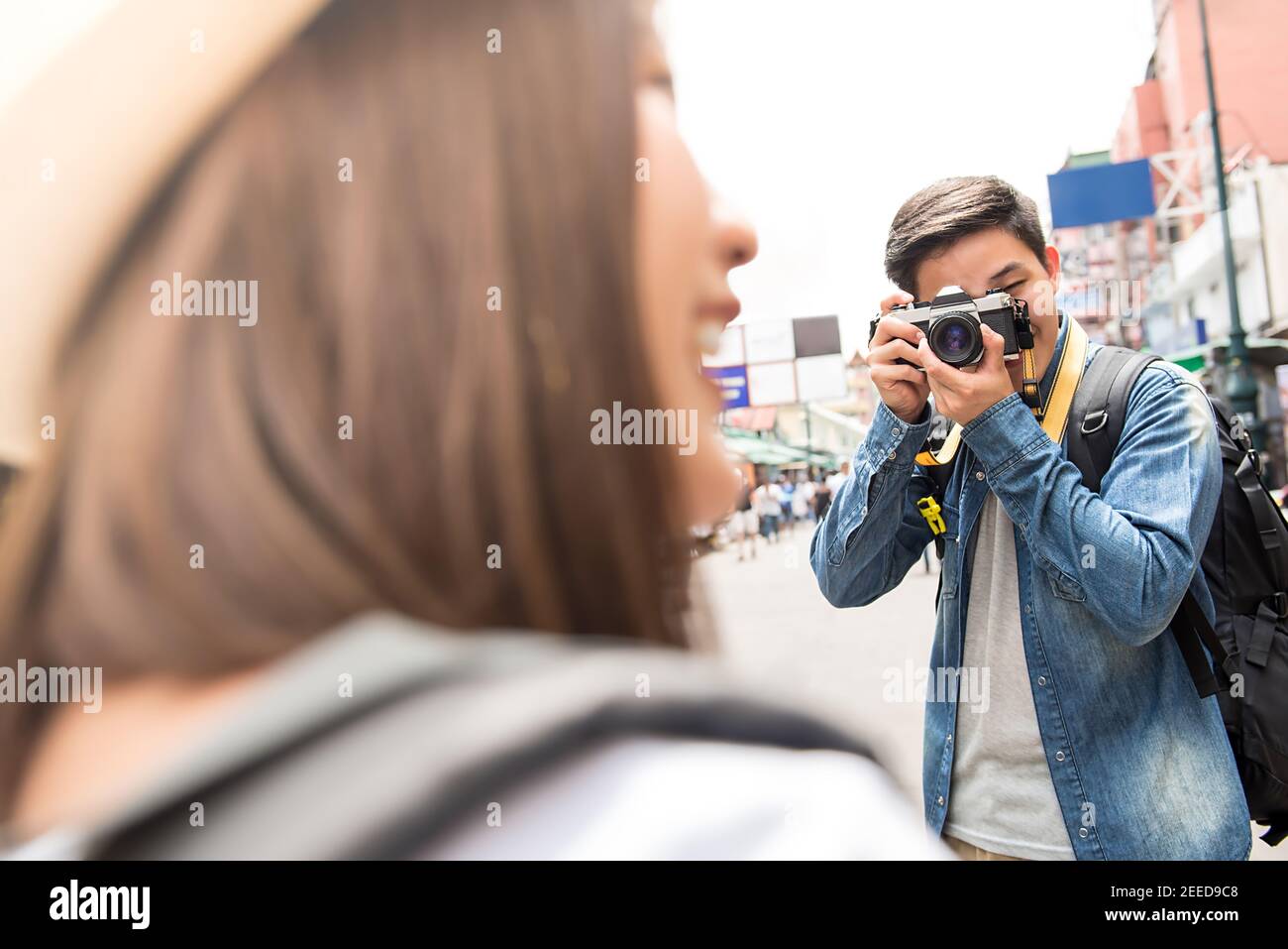 Traveling Asian couple tourist backpackers taking photo in Khao san road,  Bangkok, Thailand on holidays Stock Photo