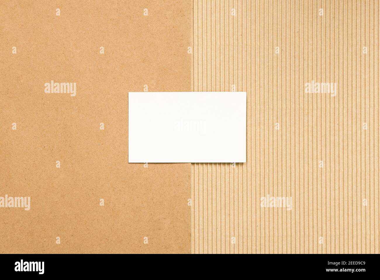 Empty white business card on brown ribbed and recycled paper. Stock Photo