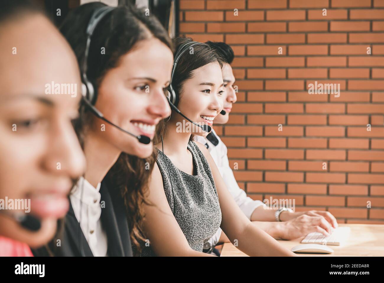 Smiling multiethnic telemarketing customer service agent team working in call center office with healpful attutude Stock Photo