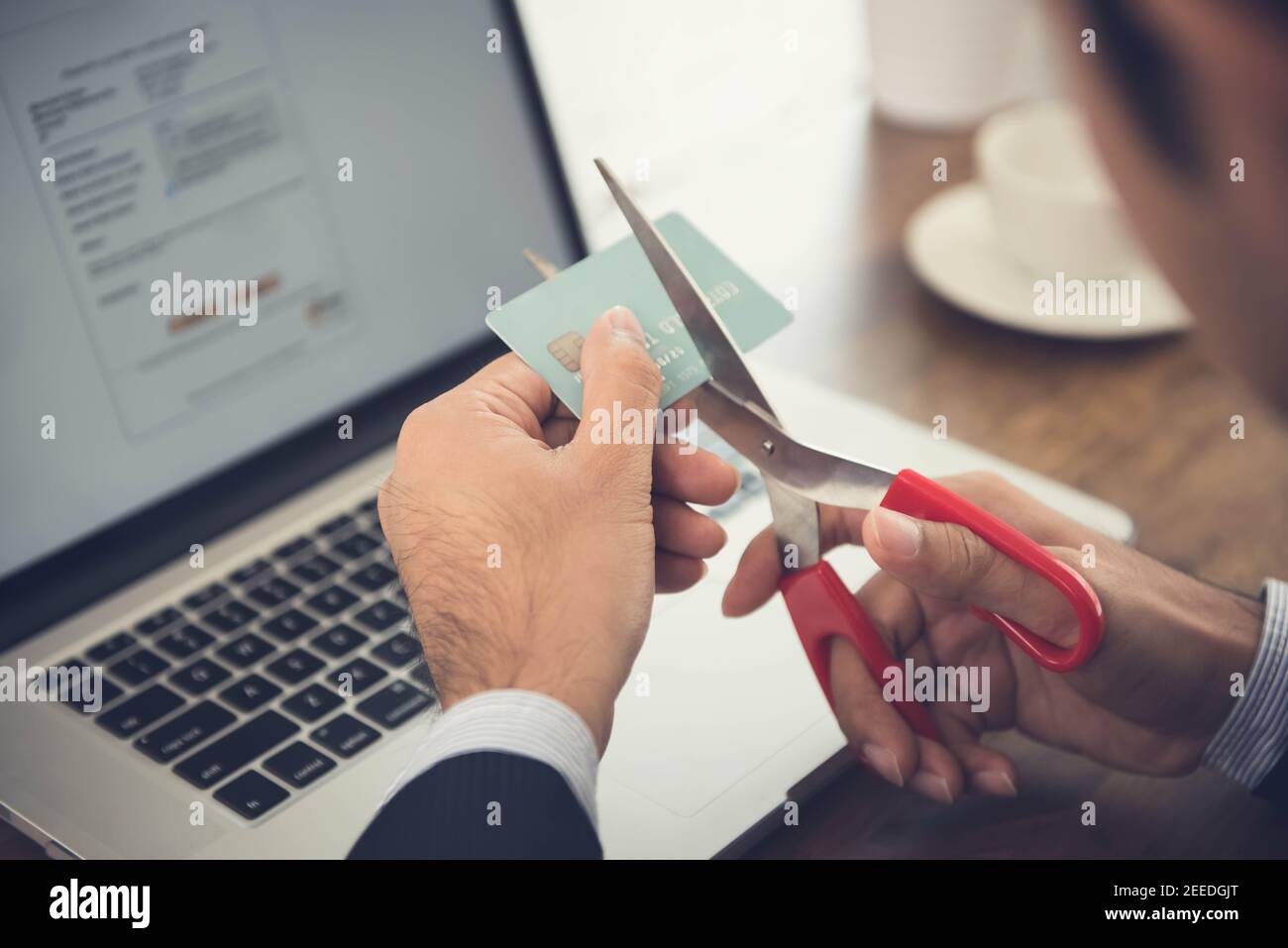 Businessman cutting a credit card that canceled by financial institute due to negligent usage Stock Photo