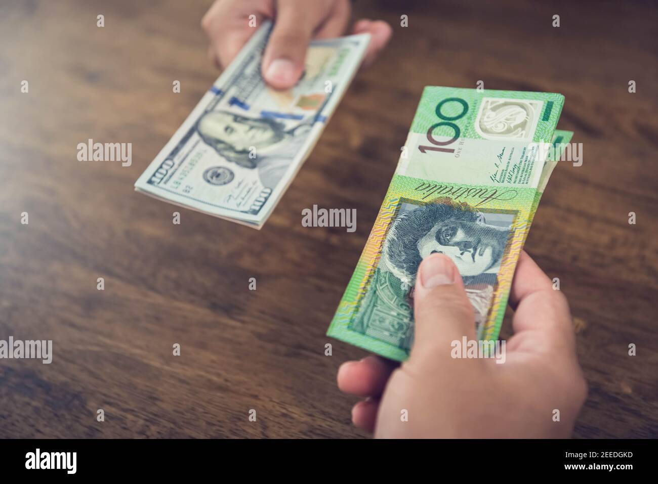 Exchanging money between US dollar (USD) and Australian dollar (AUD) banknotes Stock Photo