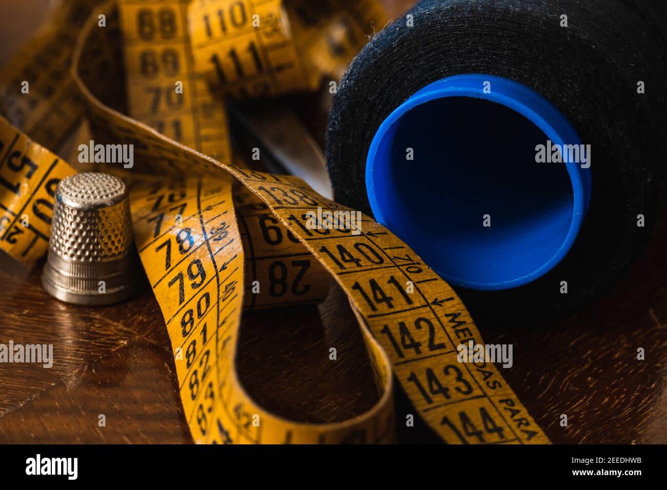 Close-up of thread, tape measure, scissors, thimble and dressmaker's objects. Stock Photo