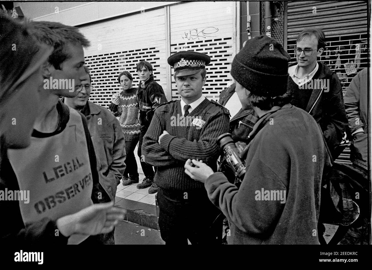 Police offiers being filmed by a video activist from Undercurrents network at the Camden High Street Reclaim The Streets anti car protest, London, 14th May 1995 Stock Photo