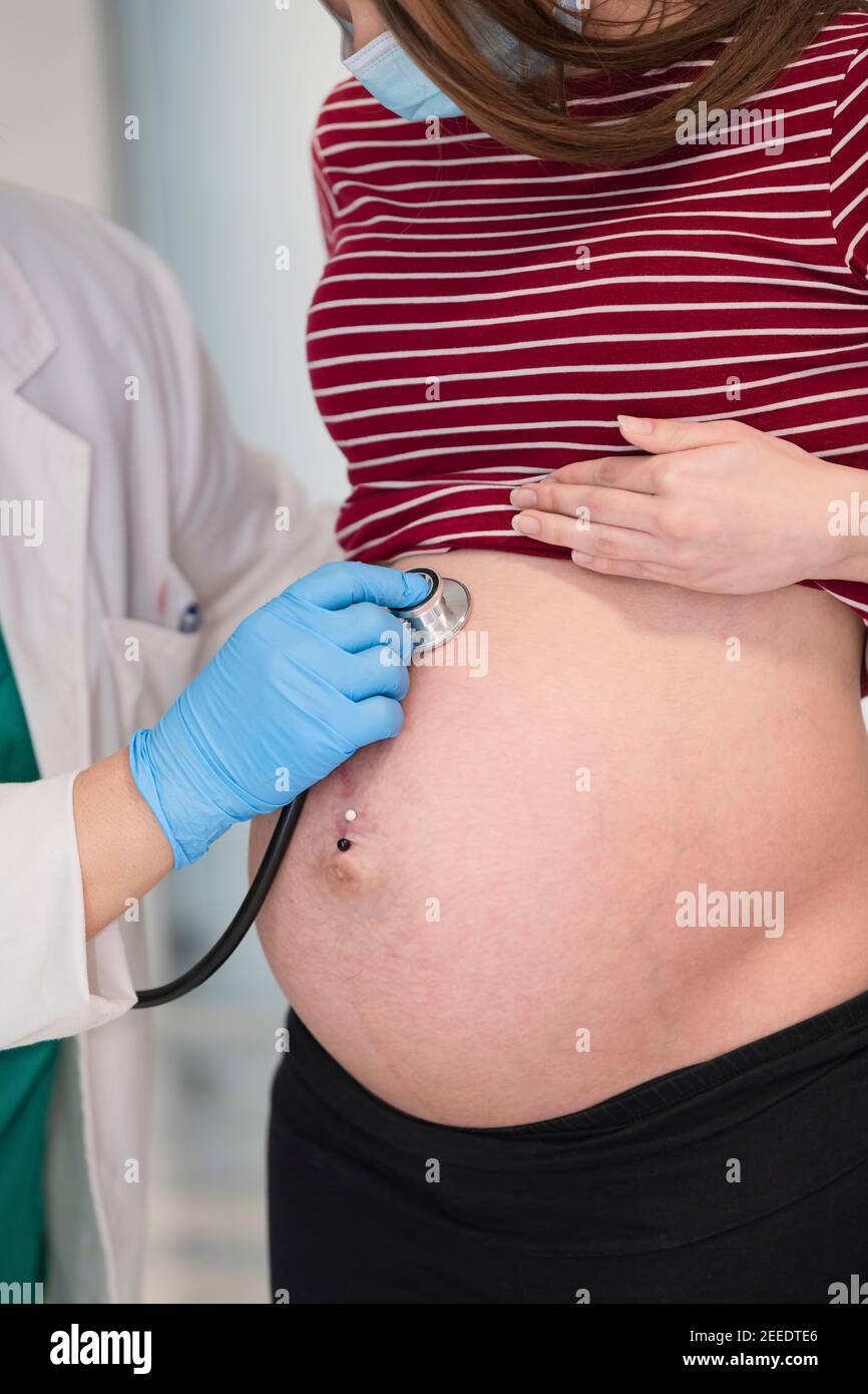 Young pregnant woman's belly being checked by a doctor using a stethoscope.  Selective focus and close up. Pregnancy and healthcare concept Stock Photo  - Alamy