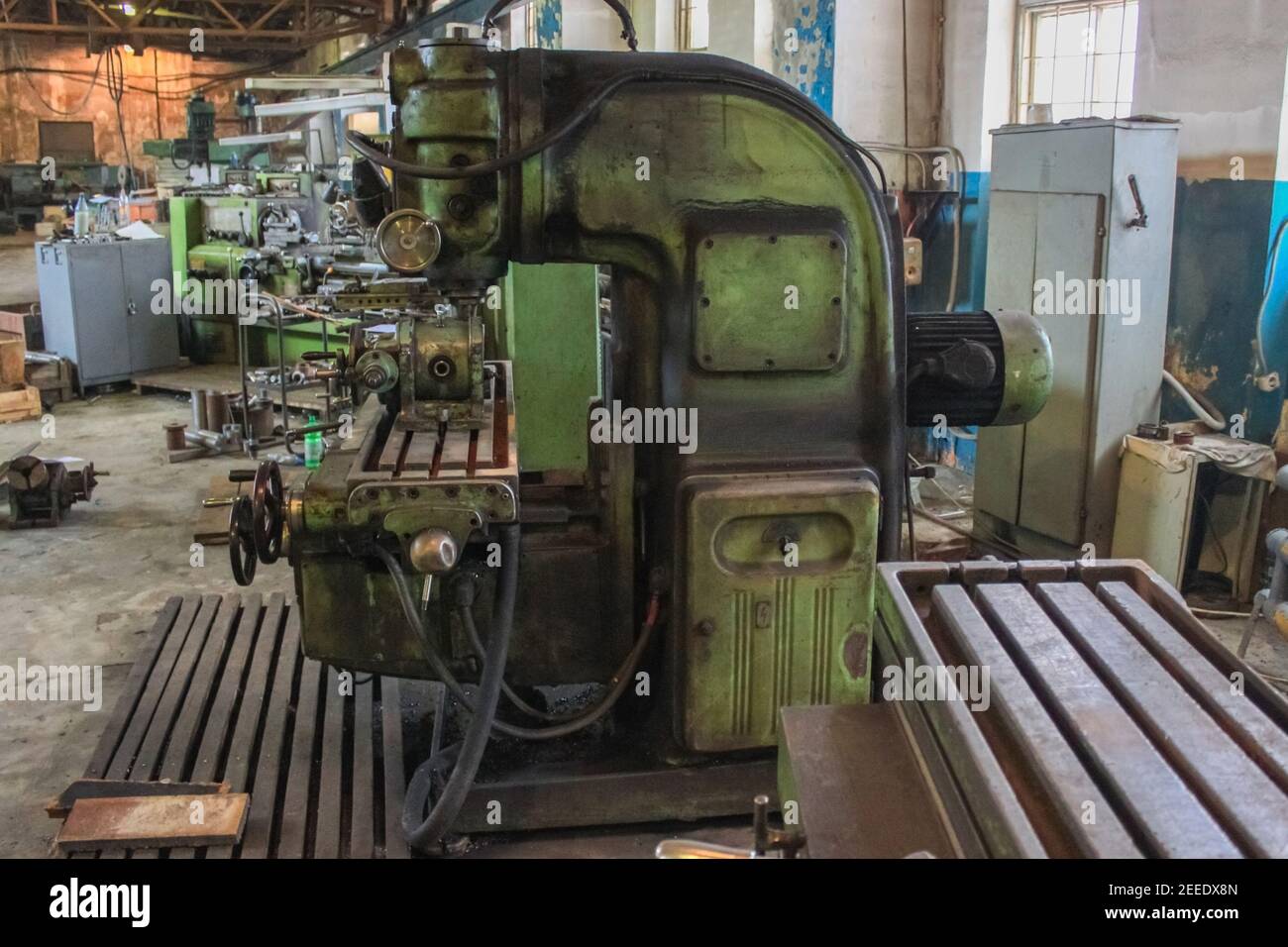 Milling machine made in the USSR in the production shop. Green, smeared