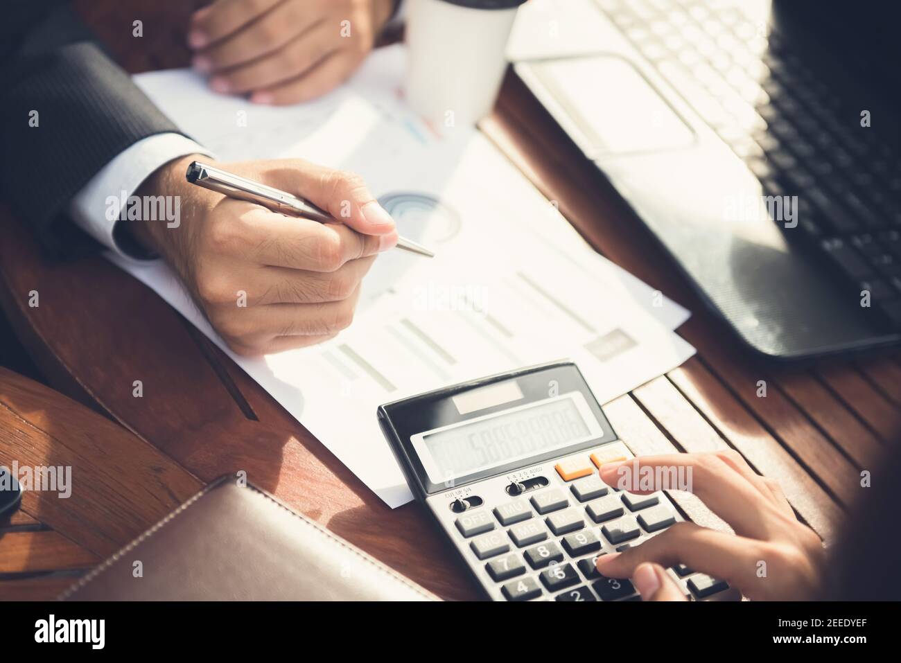 Financial adviser working with client, calculating and analyzing data at the table in cafe Stock Photo