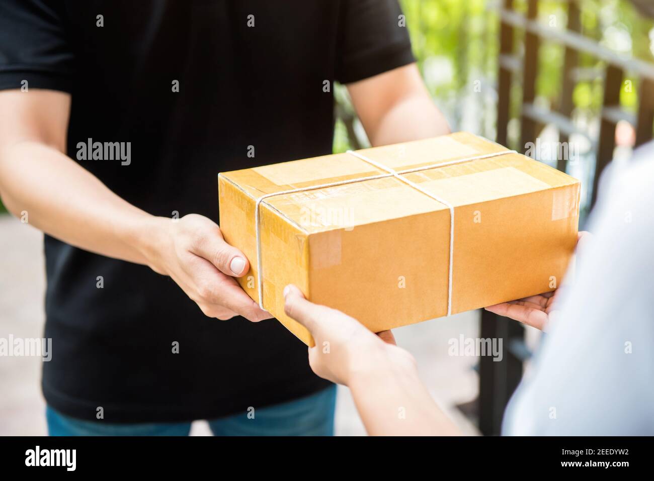 Customer receiving parcel from delivery man - courier and delivery service concept Stock Photo