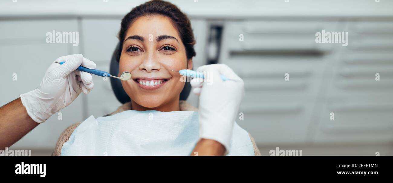 Woman getting her teeth checked by a dentist. Happy woman having dental exam at dentistry. Stock Photo