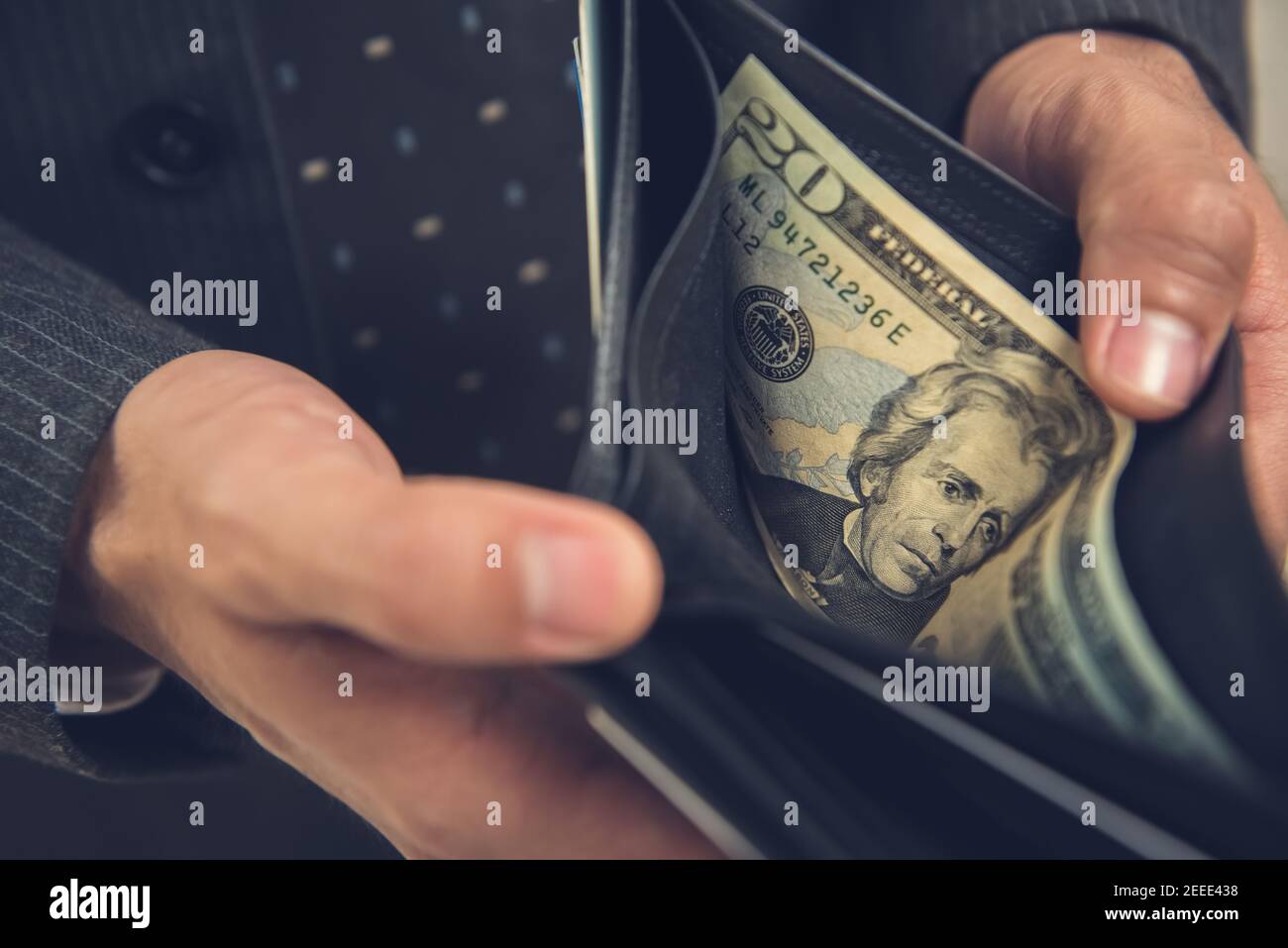 A man opening wallet showing some money, 20 US dollar bill left Stock Photo