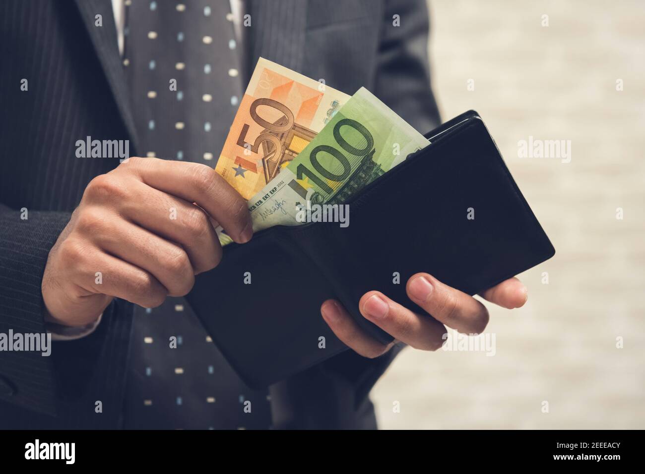 Businessman opening wallet and taking out some money, Euro currency Stock Photo