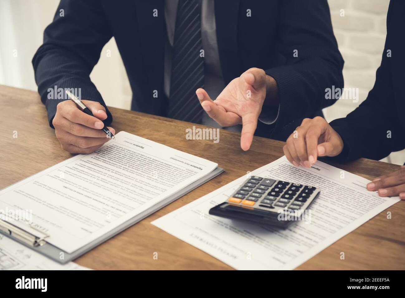 Client consulting with agent, reviewing contract about to sign Stock Photo