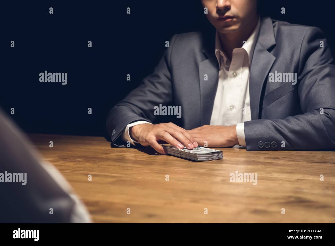 Dishonest businessman about to give money to his partner in the dark - bribery, scam and venality concepts Stock Photo