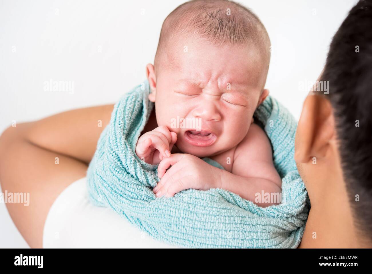 Father holding and soothing unhappy inconsolable crying little newborn baby in his arms Stock Photo