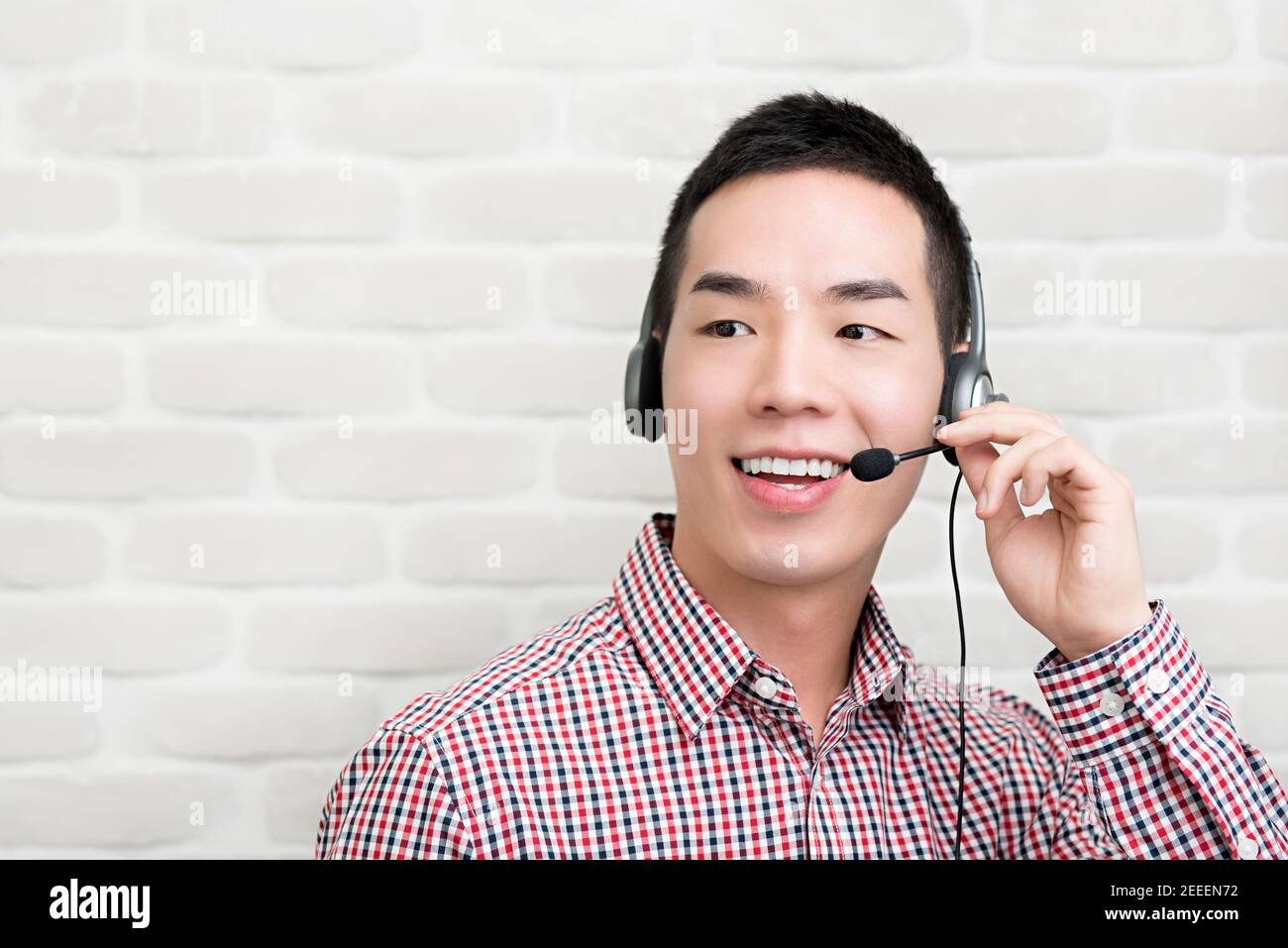 Casual Asian businessman wearing microphone headset  as a telemarketing customer service agent, call center job concept Stock Photo