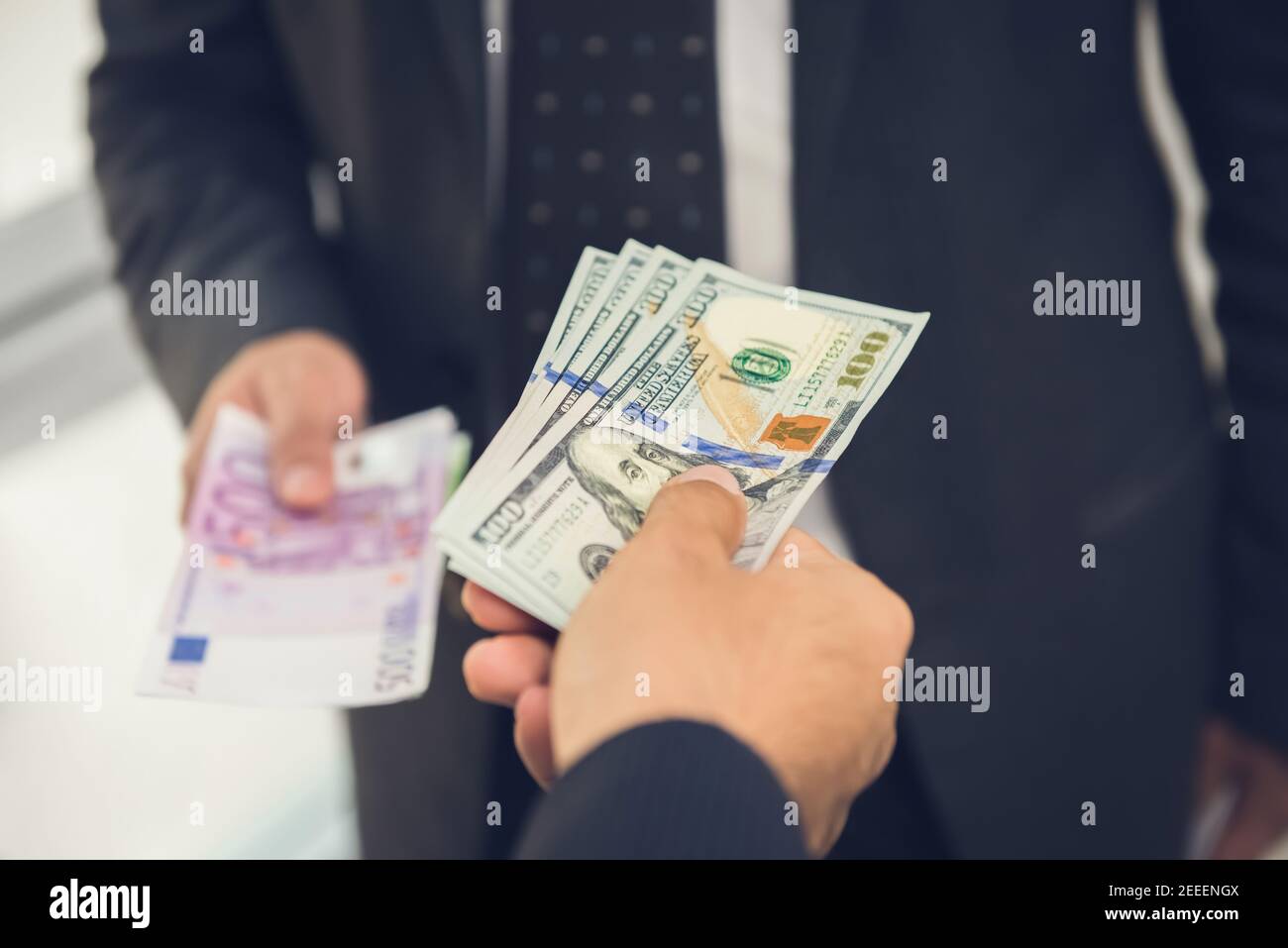 Businessman exchanging money US dollar bills with Euro currency Stock Photo