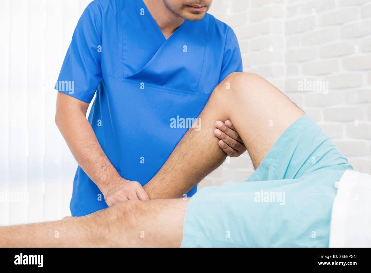Physiotherapist training rehab exercise to broken leg patient in hospital Stock Photo