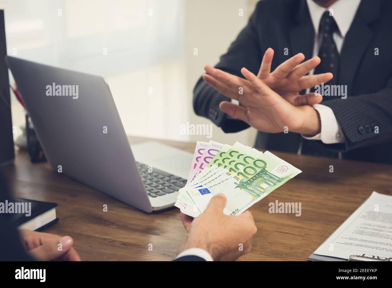 Businessman rejecting money, Euro banknotes, from his partner while making contract - anti bribery concept Stock Photo
