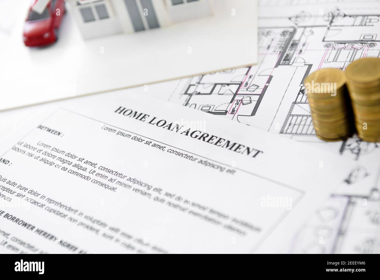 Home loan agreement form paper with house model, blueprint and some money on the table - real estate financial concept Stock Photo