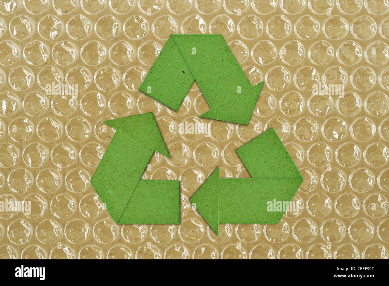 Green cardboard recycling symbol on plastic bubble wrap Concept of paper and plastic recycling