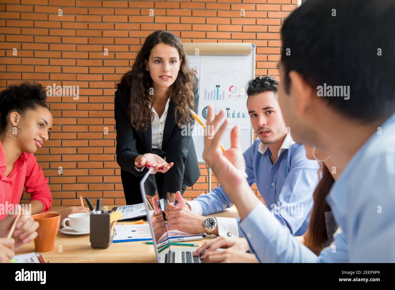 Businesswoman as a meeting leader asking her colleague for an opinion while making a presentation Stock Photo